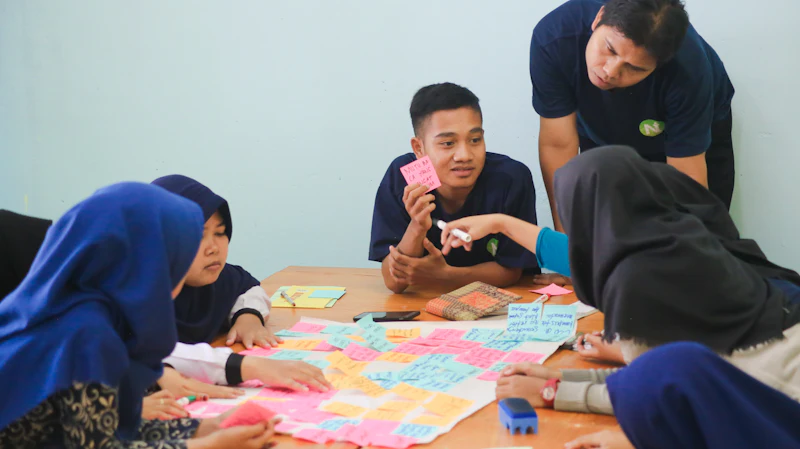Des jeunes femmes et hommes réunis autour d’une table couverte de post-it, en plein atelier participatif.